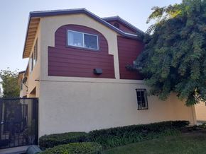 Los Angeles apartment for rent - A house with a red and beige exterior and a black gate.
