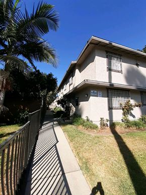 North Hollywood apartment for rent - A house with a black fence and a tree in front of it.