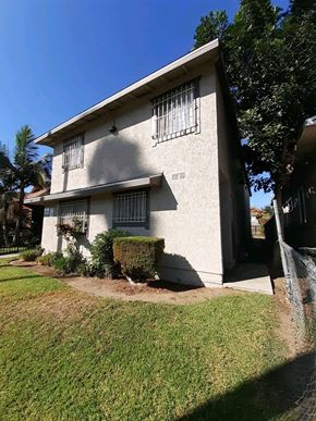 North Hollywood apartment for rent - A white house with a green lawn in front.
