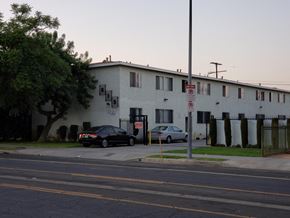 Los Angeles apartment for rent - A black car is parked in front of a white building with a no parking sign.