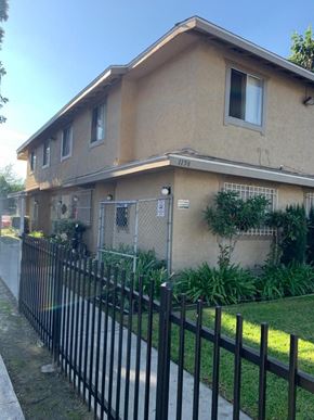 Los Angeles apartment for rent - A beige house with a black fence in front.