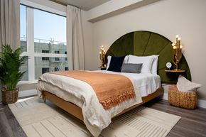 Los Angeles apartment for rent - A bedroom with a large bed and a round green headboard.