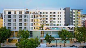 Los Angeles apartment for rent - A modern multi-story building with a pool in the middle.