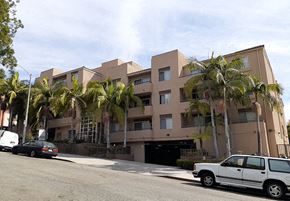 Los Angeles apartment for rent - a building with palm trees and cars parked in front of it