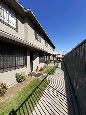 Los Angeles apartment for rent - A sunny day at a residential area with apartment buildings and a sidewalk.