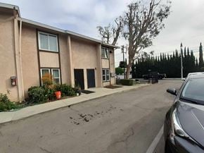 Los Angeles apartment for rent - A car is parked on the side of a street in front of a building.