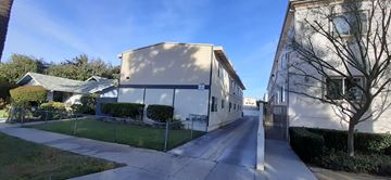 Van Nuys apartment for rent - A long, narrow road with a sidewalk on one side and a fence on the other.