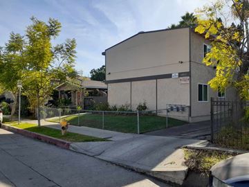 North Hollywood apartment for rent - A building with a fence and a tree with yellow leaves in front of it.