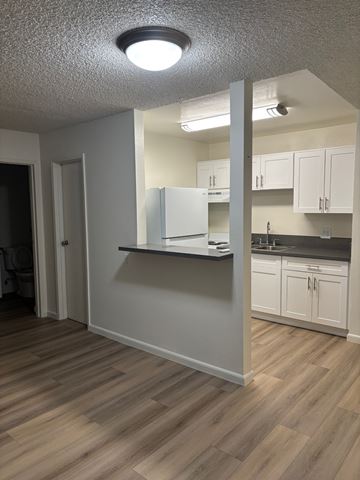 Reseda apartment for rent - A kitchen with white cabinets and a refrigerator.