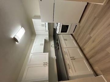 Eagle Rock apartment for rent - A kitchen with white cabinets and a wooden floor.