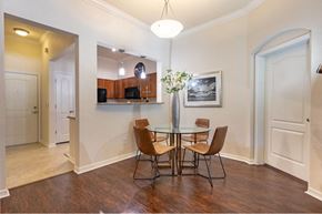 Gainesville apartment for rent - Dining room area located in front of kitchen bar. 4 seater round glass table pictured at The Bartram Apartments in Gainesville, FL 32608
