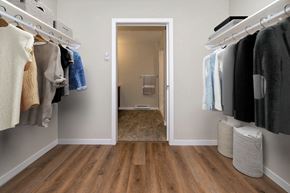 Portage La Prairie apartment for rent - a walk in closet with a door to a bathroom with clothes hanging on the wall