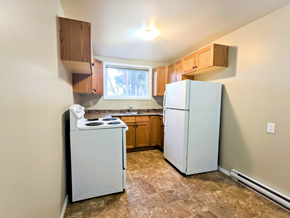 Brandon apartment for rent - an empty kitchen with white appliances and wooden cabinets