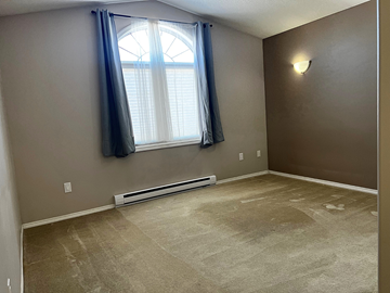 Brandon condo for rent - an empty living room with a window and a carpeted floor