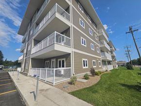 Killarney apartment for rent - A multi-story apartment building with a parking lot in front.