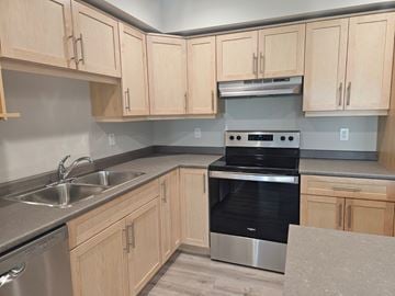 Killarney apartment for rent - A kitchen with wooden cabinets and a black oven.