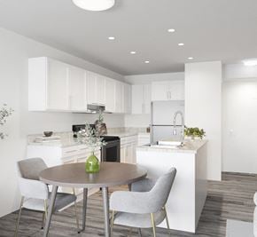 Brandon apartment for rent - a kitchen with white cabinets and a table and chairs