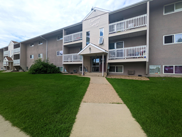 Brandon apartment for rent - an exterior view of an apartment building with a sidewalk and lawn