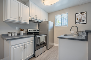 Palm Springs apartment for rent - a kitchen with white cabinets and a sink and a refrigerator