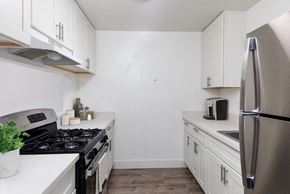 Watsonville apartment for rent - a white kitchen with stainless steel appliances and white cabinets