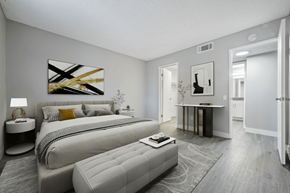 Indio apartment for rent - A modern bedroom with a large bed and a painting on the wall.