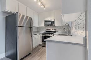Lake Elsinore apartment for rent - a kitchen with white cabinets and stainless steel appliances