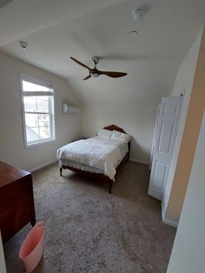 Frederick apartment for rent - A bedroom with a bed, dresser, and window.
