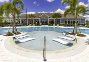 Davenport apartment for rent - a large swimming pool with white chairs and a building in the background