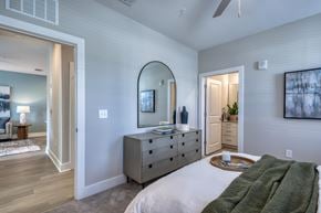 Jacksonville apartment for rent - A bedroom with a large bed and a dresser with a mirror above it.