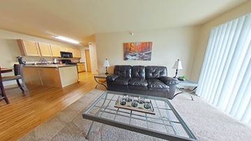 Williston apartment for rent - A living room with a black leather couch and a coffee table in the center.