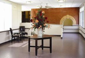 Ware apartment for rent - an empty room with a table with flowers on it