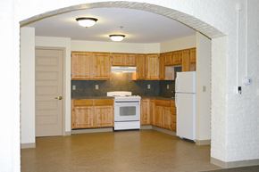 Ware apartment for rent - an empty kitchen with wooden cabinets and a white stove and refrigerator