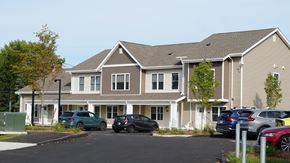 Ludlow apartment for rent - A large two-story building with a parking lot in front.