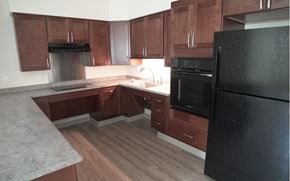 Holyoke apartment for rent - a kitchen with dark wood cabinets and a black refrigerator