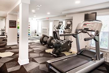 A spacious fitness room with treadmills and elliptical trainers