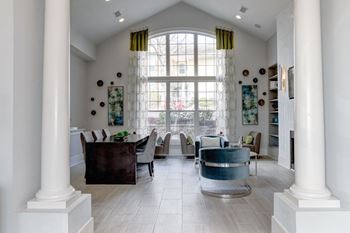 A living room with a large window and a table and chairs