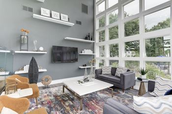 A living room with a large window and a tv on the wall