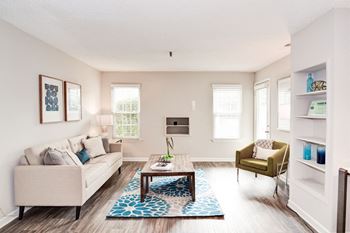 A living room with white walls and hardwood flooring