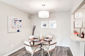 A dining room with a table and chairs