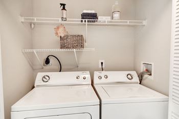 A small laundry room with two washers and a dryer