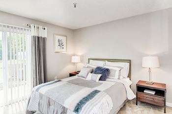 A bedroom with a bed and two night stands with lamps