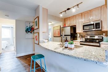 A kitchen with a granite counter top and stainless steel appliances