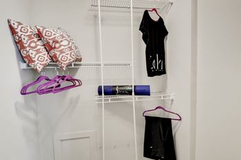A rack for clothes and shoes hangs on the wall in a small room