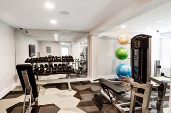 A spacious fitness room with weights and other exercise equipment