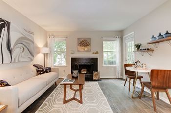 A living room with a couch table and chairs and a fireplace
