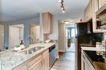 A kitchen with wood cabinets and granite countertops