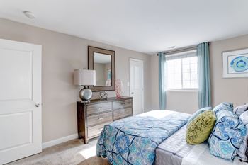 A bedroom with a bed and a dresser with a mirror