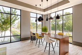 Elkridge apartment for rent - a dining room with large windows and a wooden table and chairs