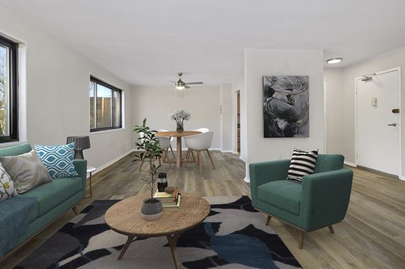 Wheaton apartment for rent - a living room with two green couches and a table with a chair at Earle Manor Apartments, Maryland, 20902