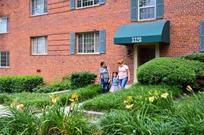 Hyattsville apartment for rent - two women and a child walking in front of a brick building at Hamilton Manor Apartments, Hyattsville